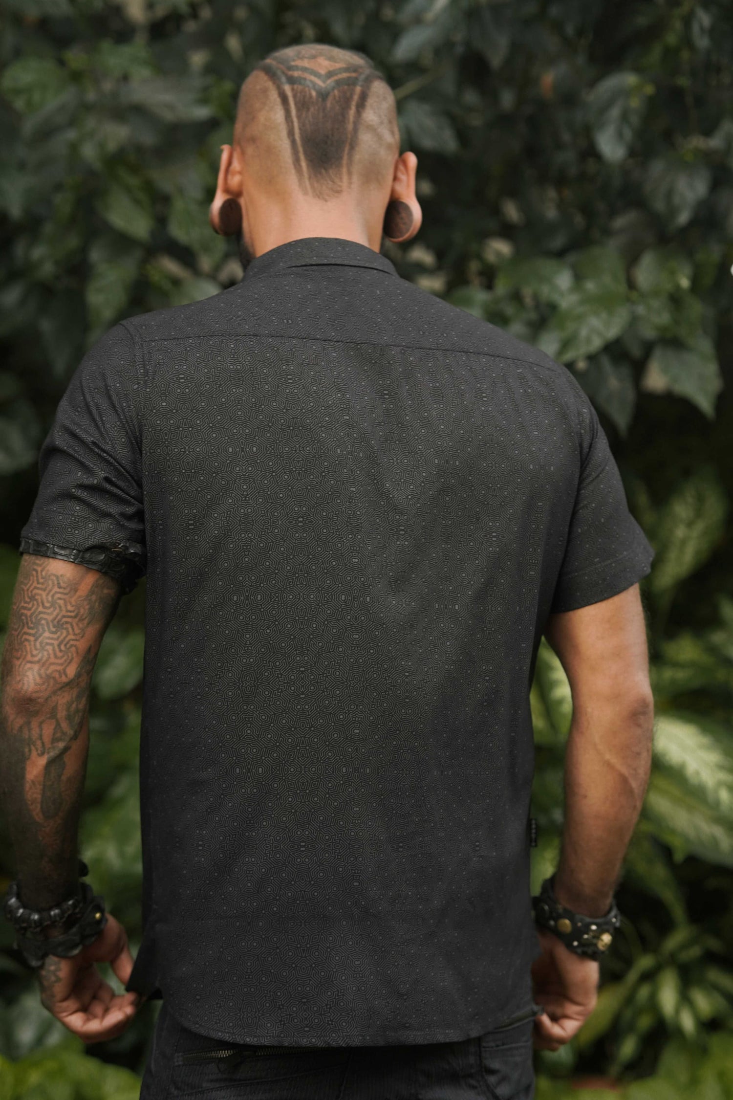 Back view of a men's short sleeve viscose shirt in black with abstract screen-printed pattern, ideal for casual summer wear.