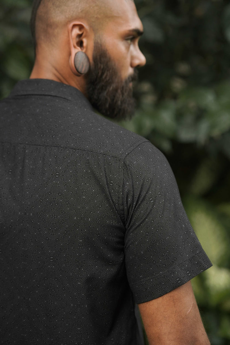 Back angled view of Tetrahedron black men's viscose shirt featuring geometric all-over pattern