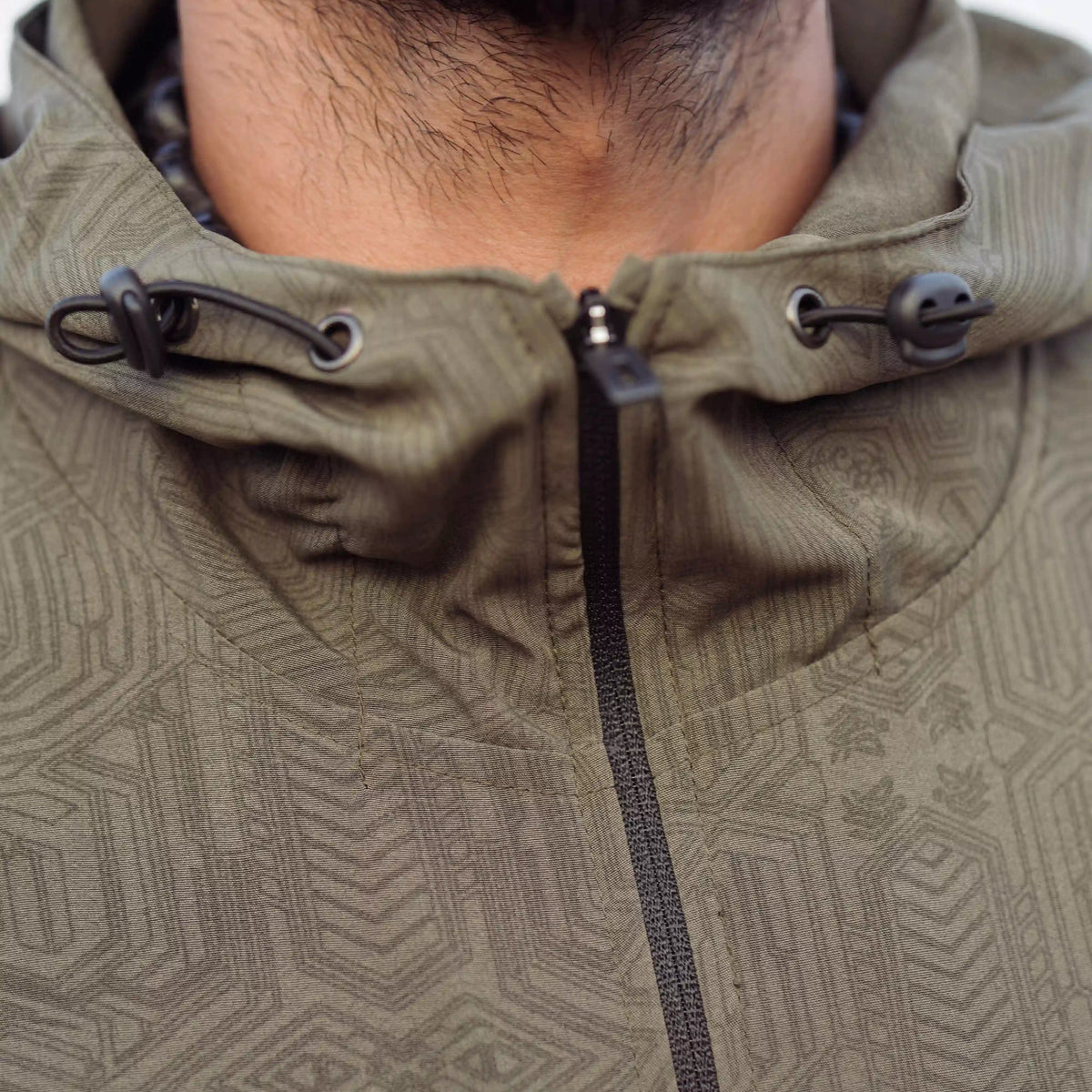 Khaki psychedelic windbreaker jacket front view with adjustable hood drawstrings and zipper