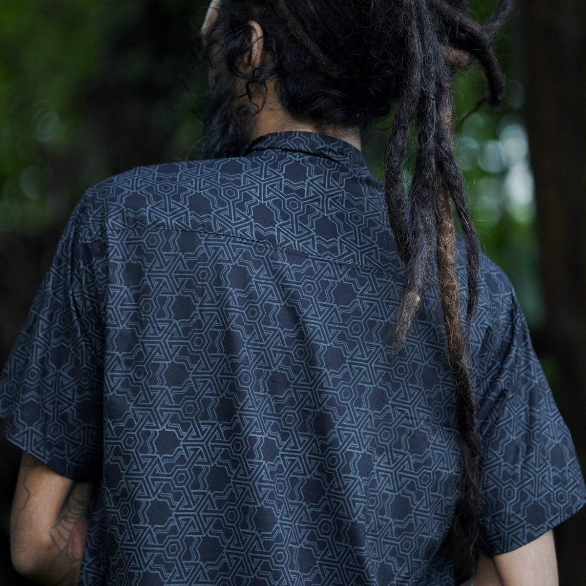 Back view of Pythagoras black men's viscose shirt with all-over sacred geometry artwork