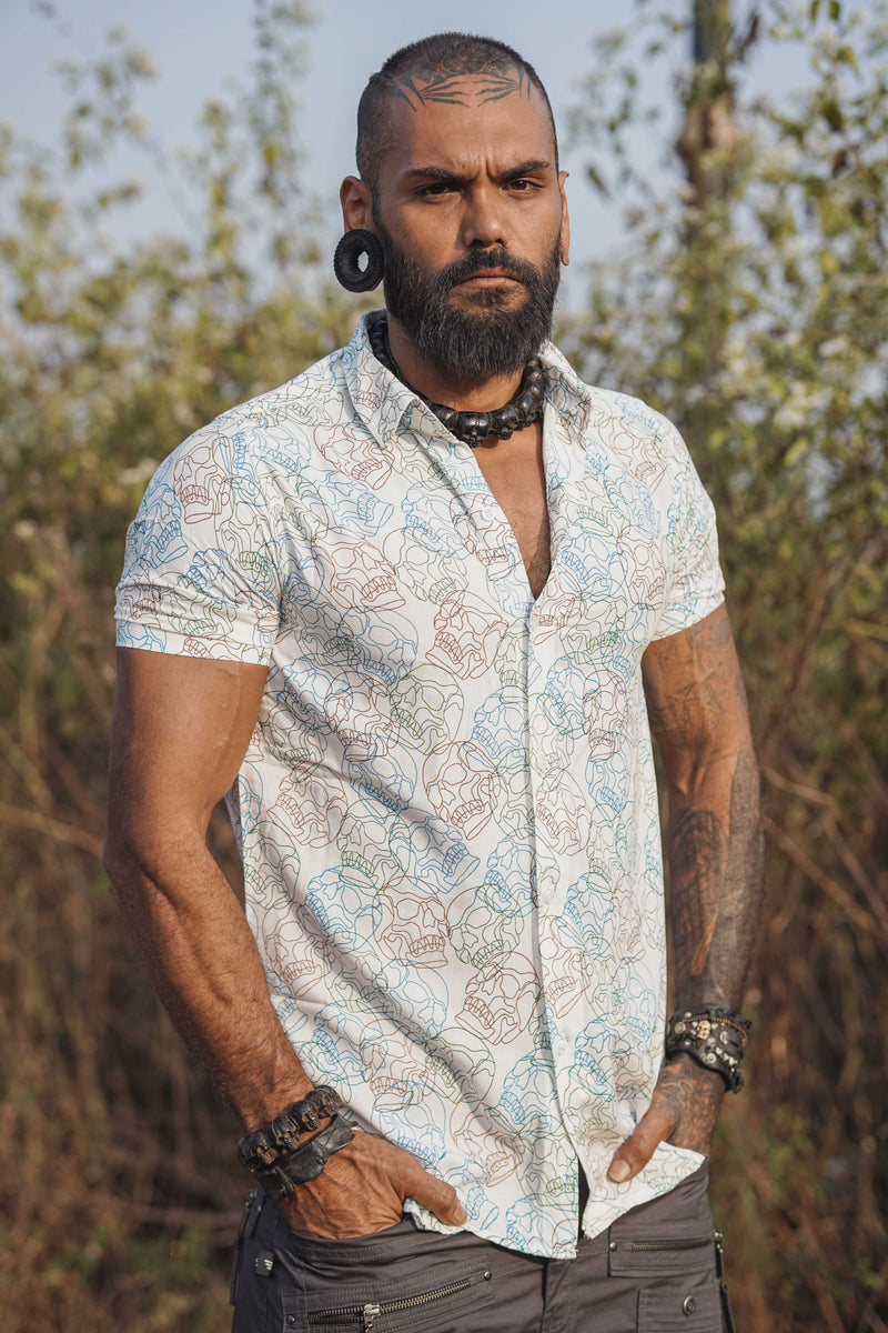 Model wearing white skull print shirt with short sleeves in outdoor setting