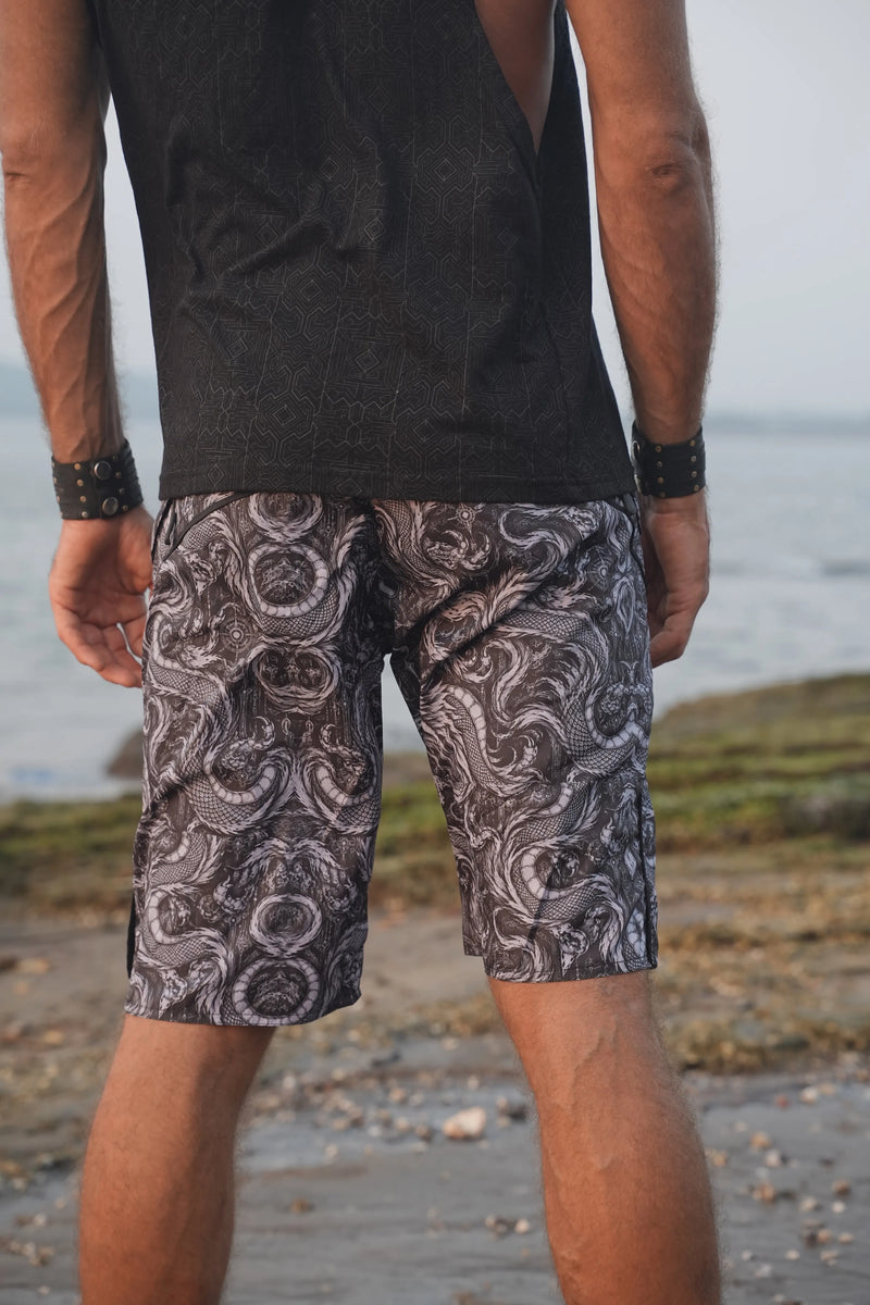 Back view of Abstract Dragon men's swim shorts showing the continuous dragon print and contrasting black waistband.
