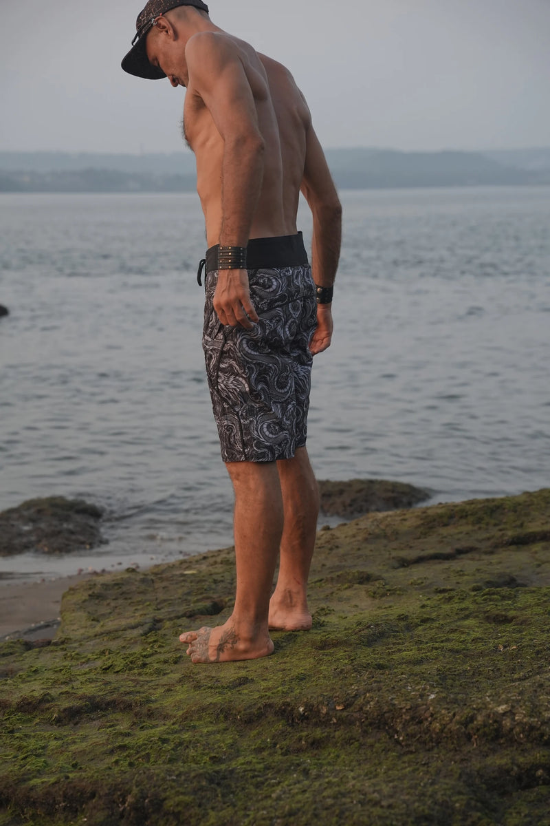 Men's Abstract Dragon psychedelic board shorts featuring detailed black and grey dragon artwork, styled for a relaxed beach look.