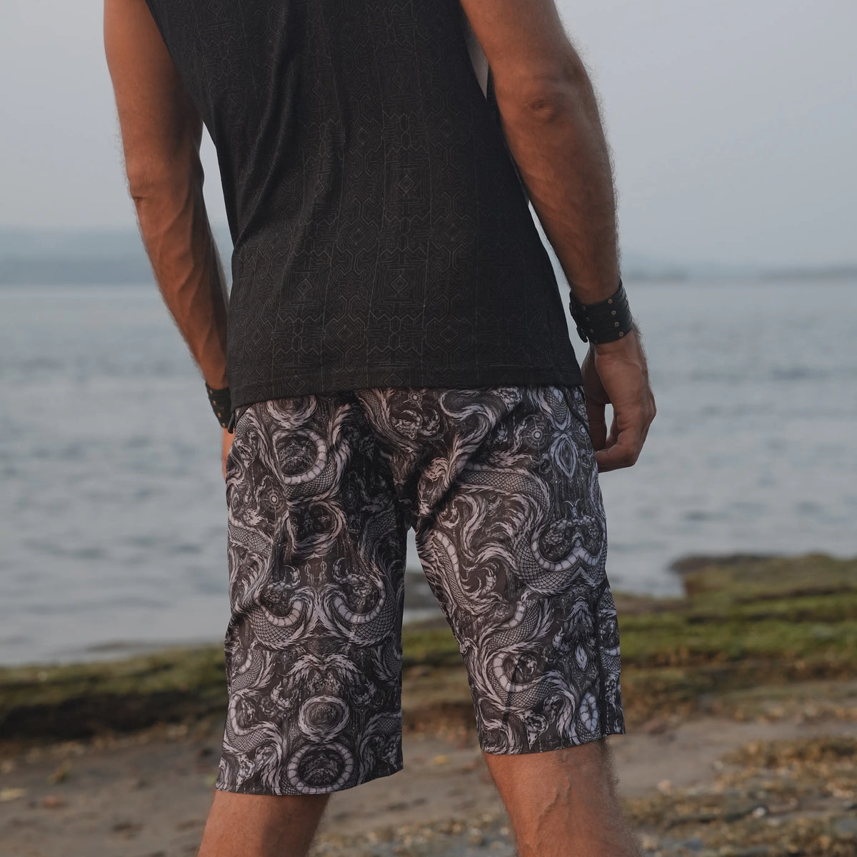 Rear view of men's Abstract Dragon psychedelic board shorts displaying the all-over black, grey and white dragon pattern.
