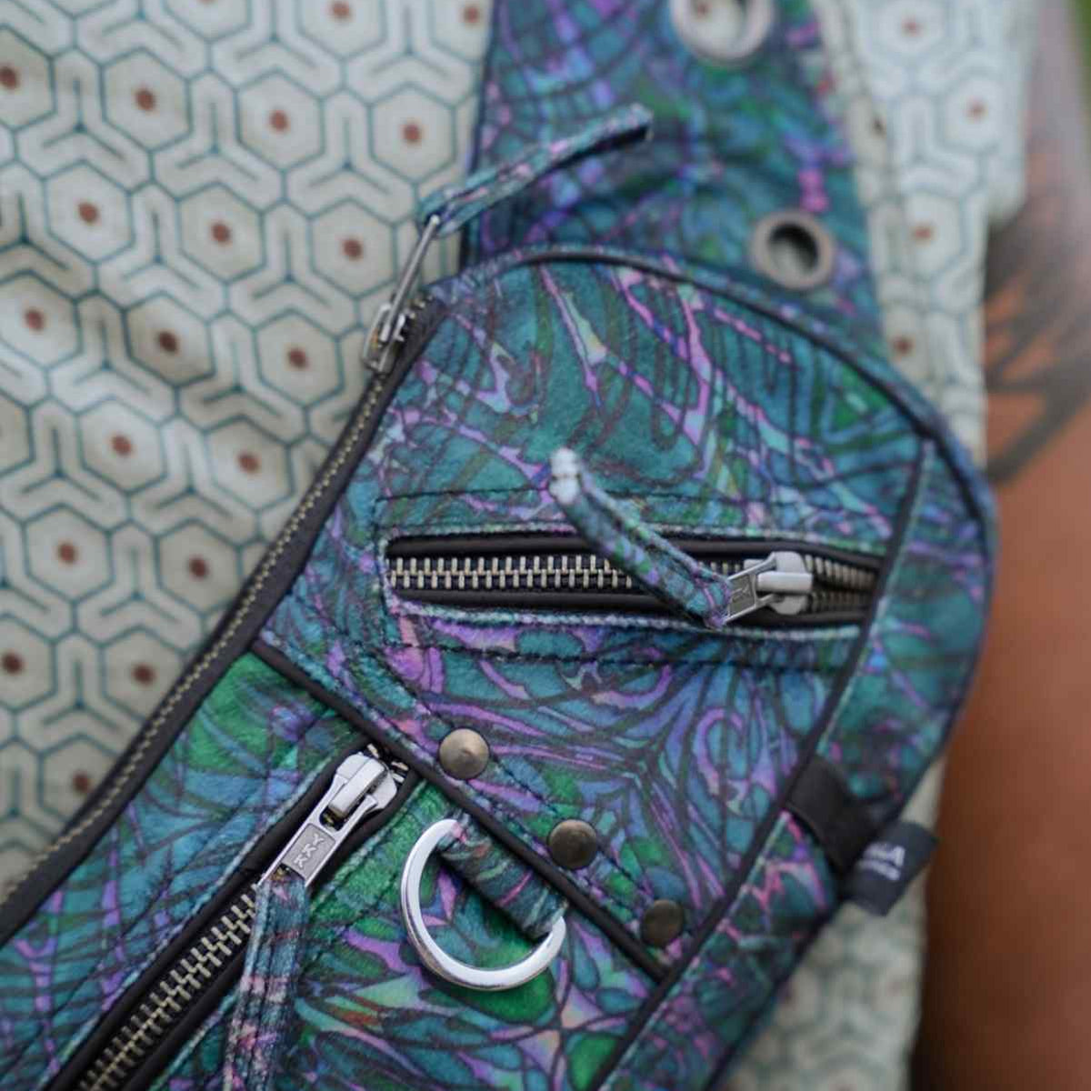 After Burn festival crossbody bag close-up showing front zipper compartments and metal D-ring