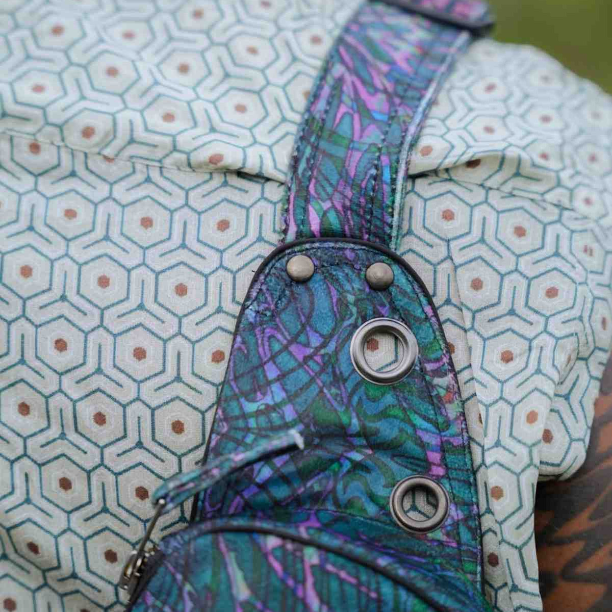 After Burn crossbody bag close-up showing patterned strap and metal eyelets