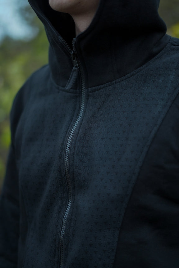 Rear view of the Clover Vortex black hoodie with tonal patterning on the back and hood