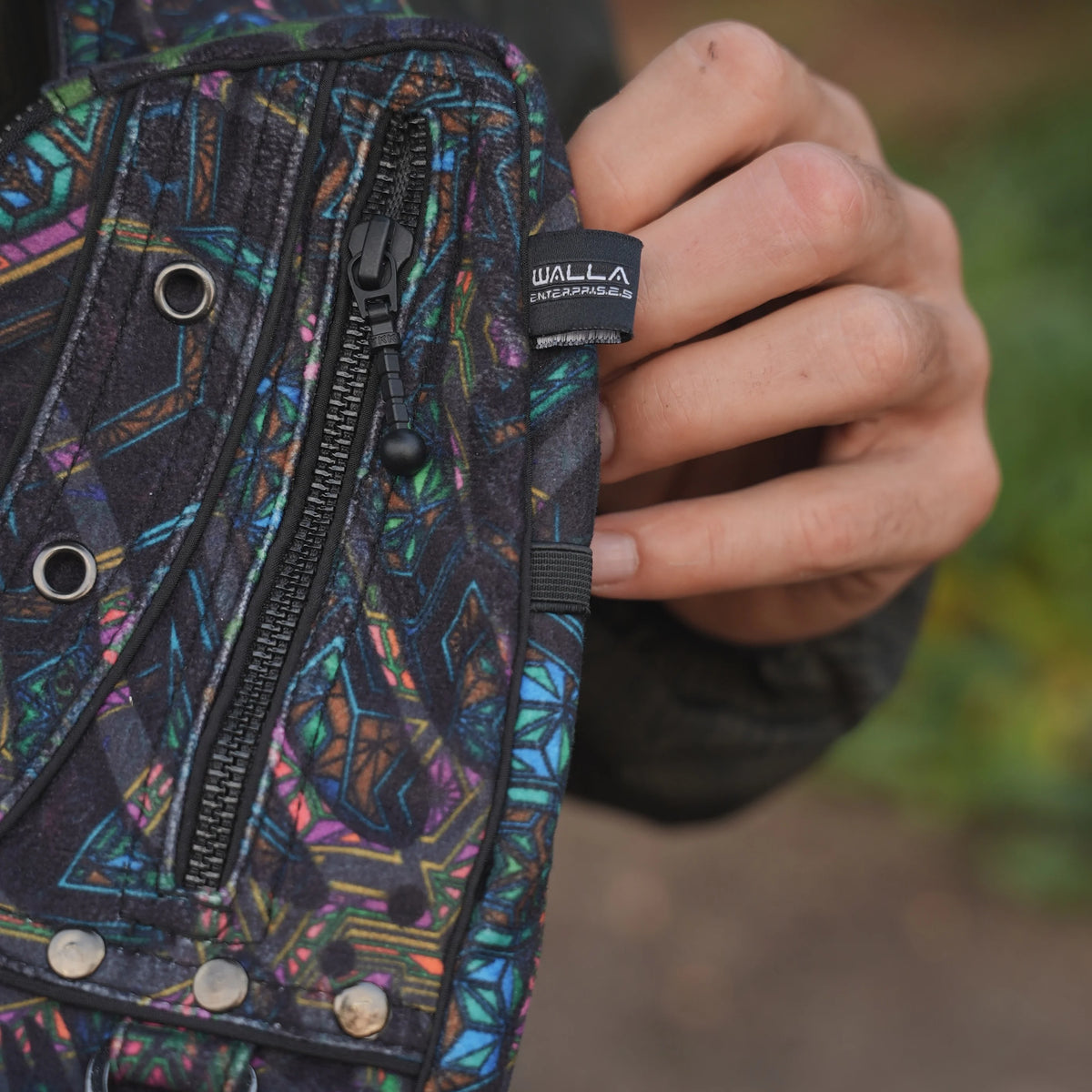Close-up of the Aztech 2.0 bag showing a YKK zipper and colourful geometric suede velvet fabric