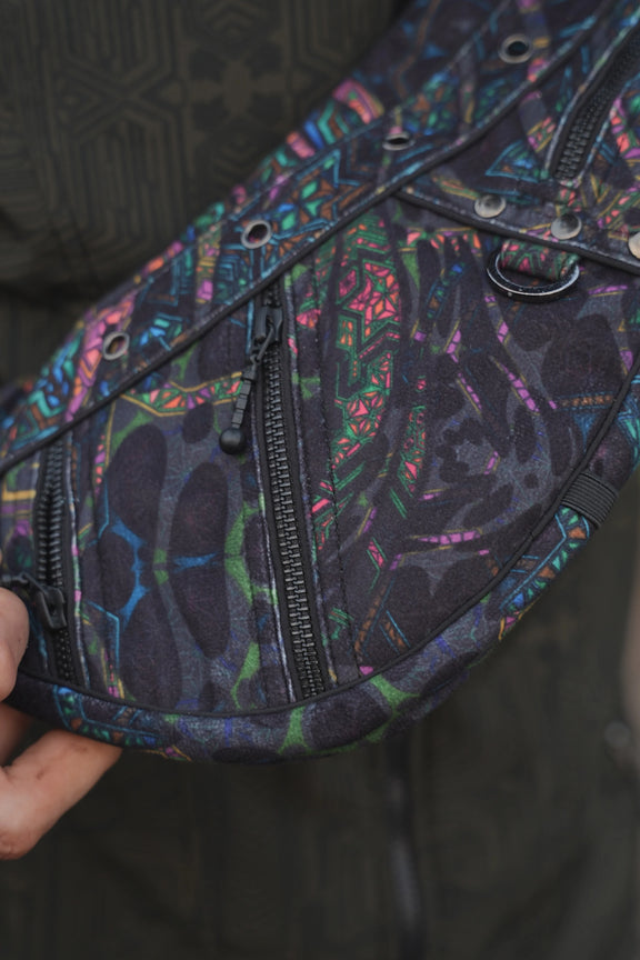 Close-up of the Aztech 2.0 bag showing a YKK zipper and colourful geometric suede velvet fabric