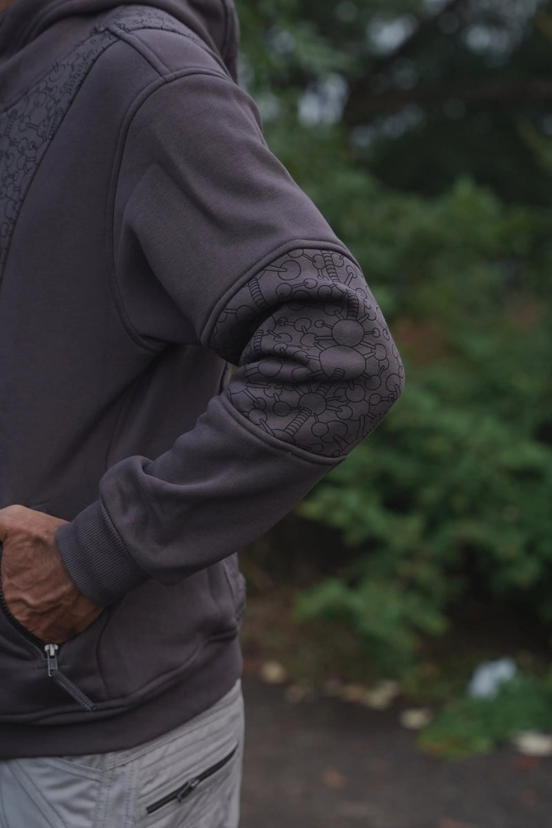 Close-up of the grey hoodie sleeve showing its dark geometric patterned elbow panel
