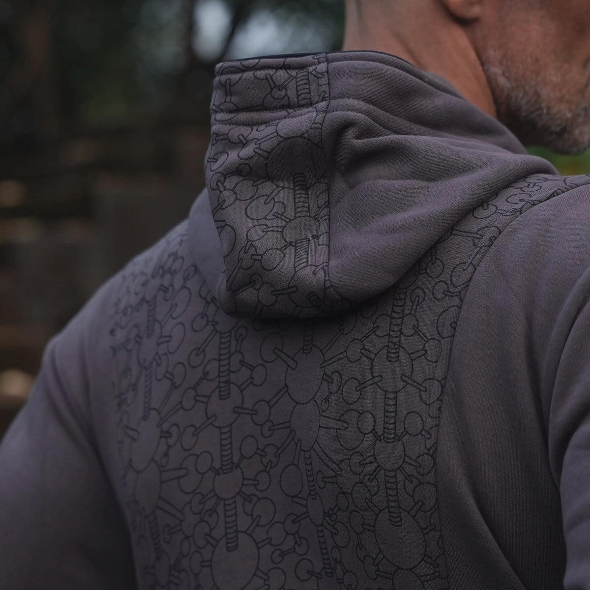 Close-up of the Fractal Gravity grey hoodie showing geometric artwork across the hood and upper back