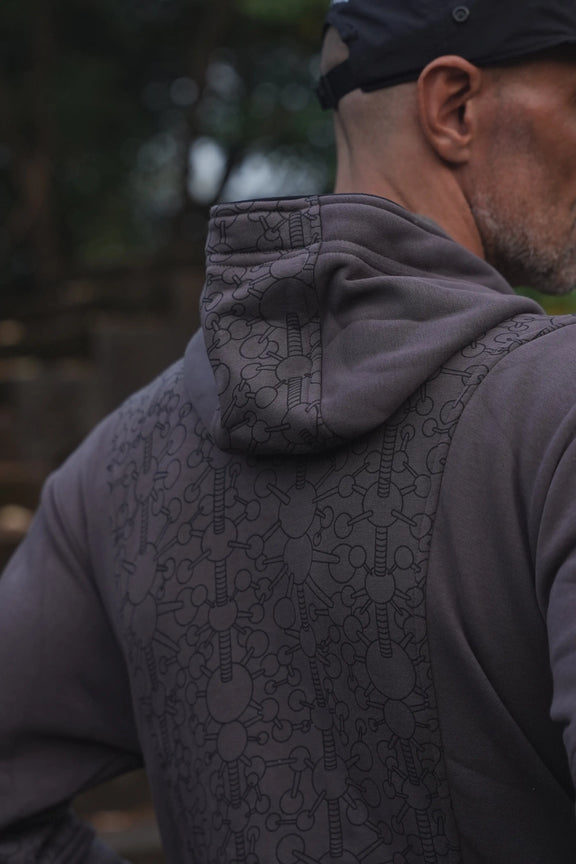 Close-up of the Fractal Gravity grey hoodie showing geometric artwork across the hood and upper back
