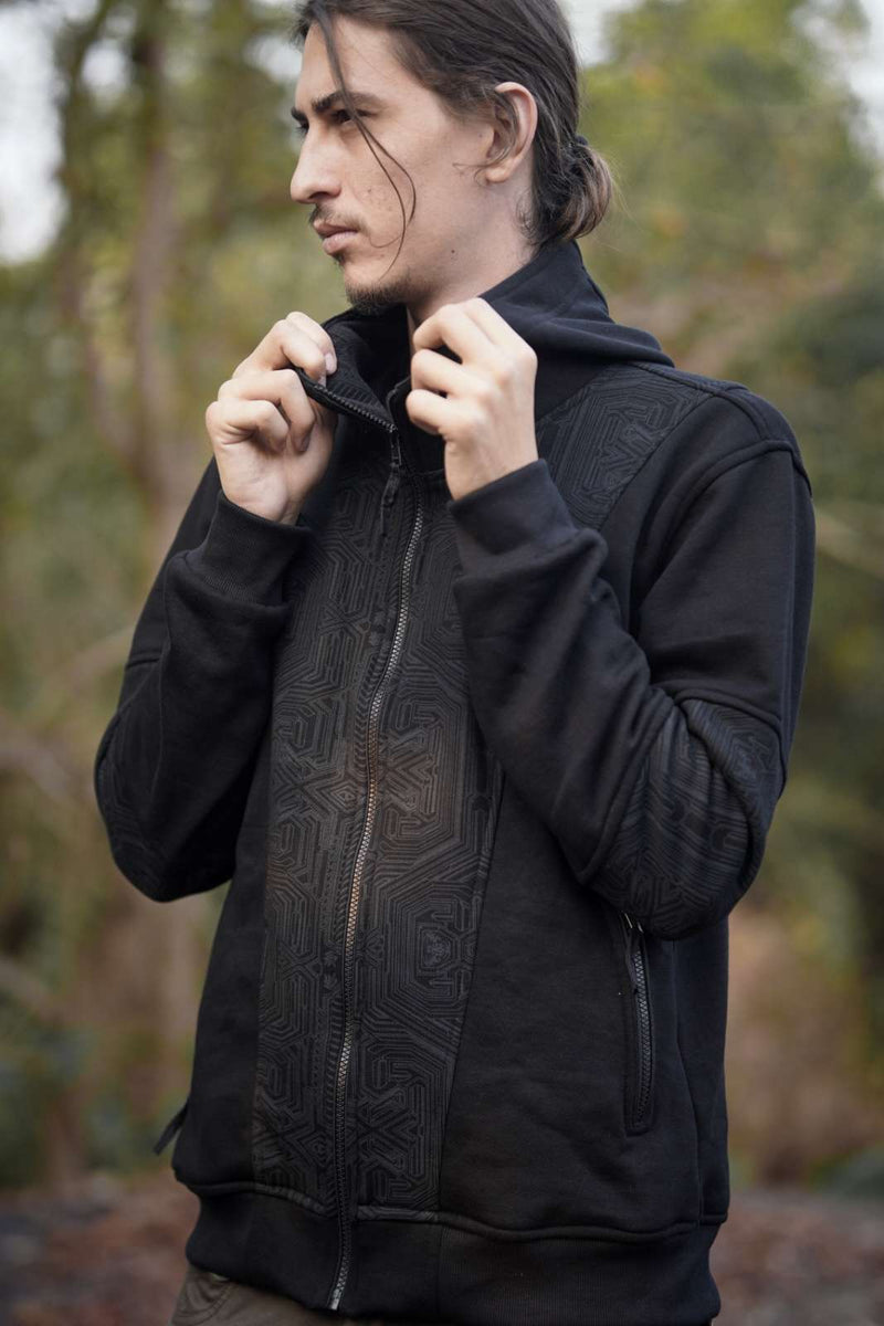 Metanoia black zip-up hoodie with tonal geometric artwork and raised collar