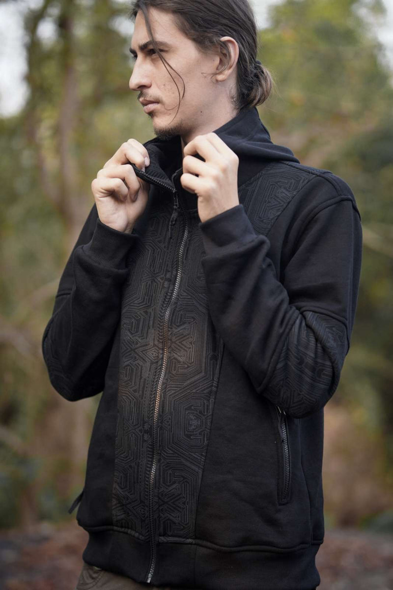 Metanoia black zip-up hoodie with tonal geometric artwork and raised collar