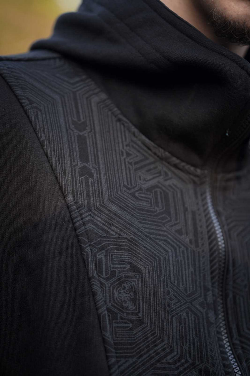 Close-up of the Metanoia hoodie's black geometric pattern across the chest and sleeve