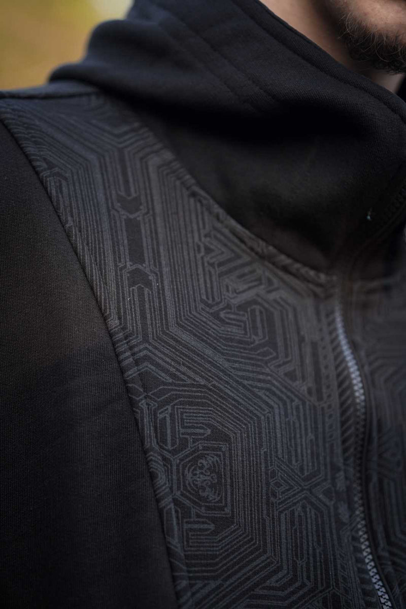 Close-up of the Metanoia hoodie's black geometric pattern across the chest and sleeve