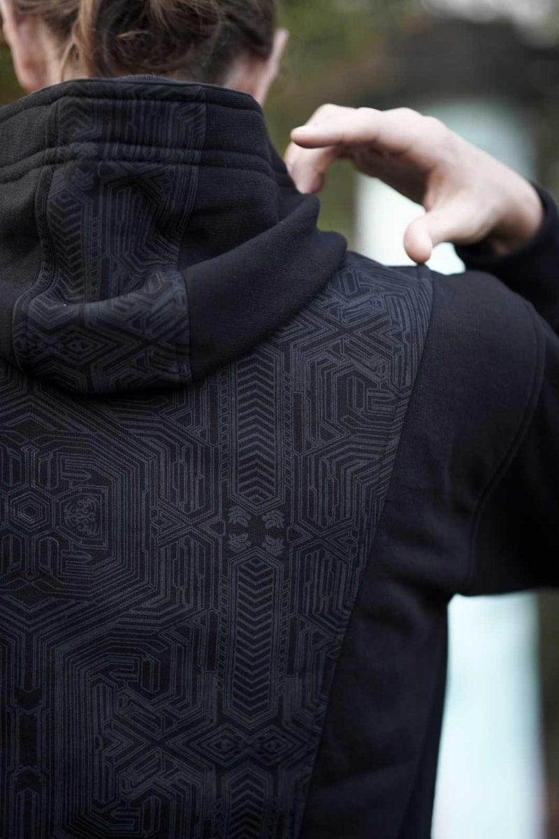 Close-up of the Metanoia hood and upper back with tonal geometric artwork
