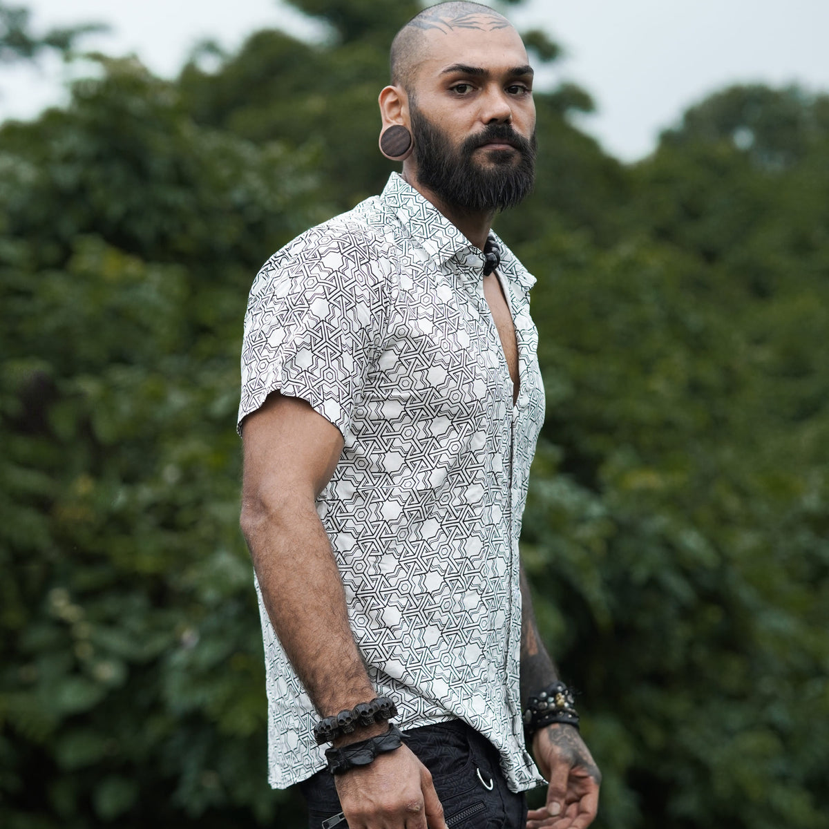 Side view of Pythagoras white men's viscose shirt worn with black shorts outdoors