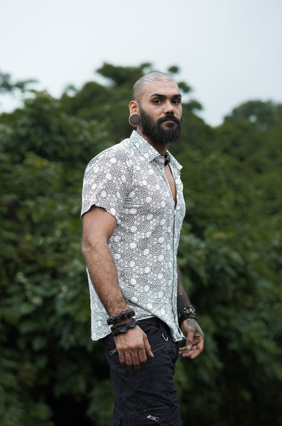 Side view of Pythagoras white men's viscose shirt worn with black shorts outdoors