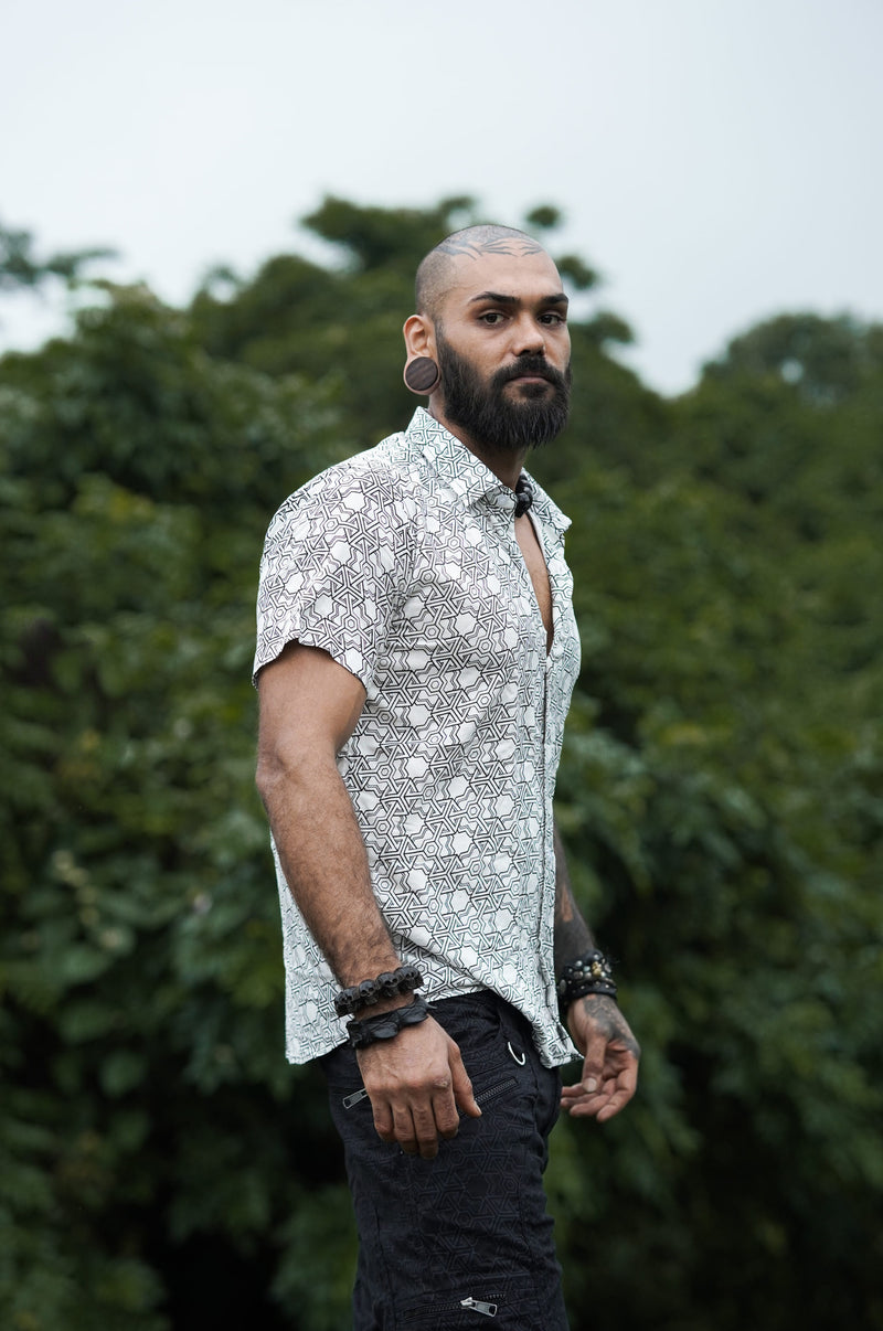 Side view of Pythagoras white men's viscose shirt worn with black shorts outdoors