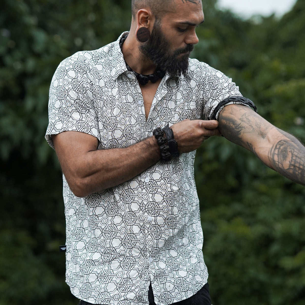 Model wearing Pythagoras white men's viscose shirt adjusting rolled short sleeve outdoors
