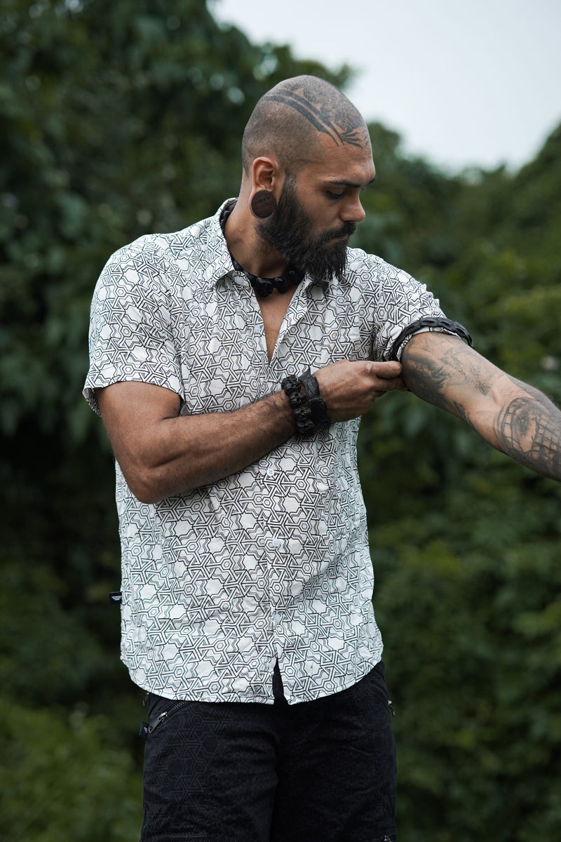 Model wearing Pythagoras white men's viscose shirt adjusting rolled short sleeve outdoors