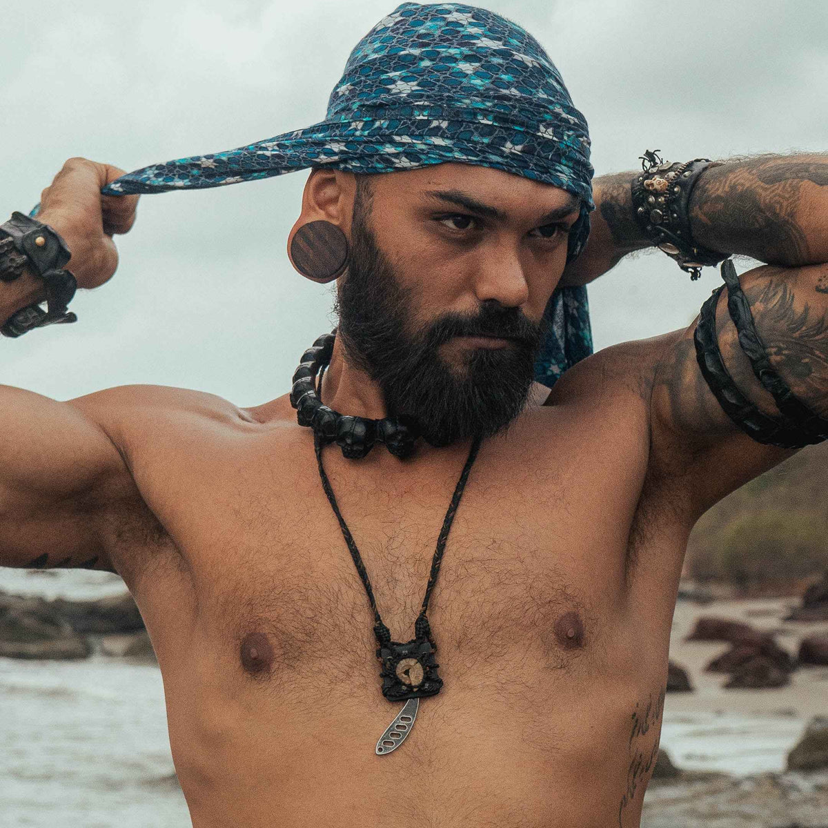 Man wearing Realm of Metatron bamboo scarf with sacred geometry print styled as a head wrap