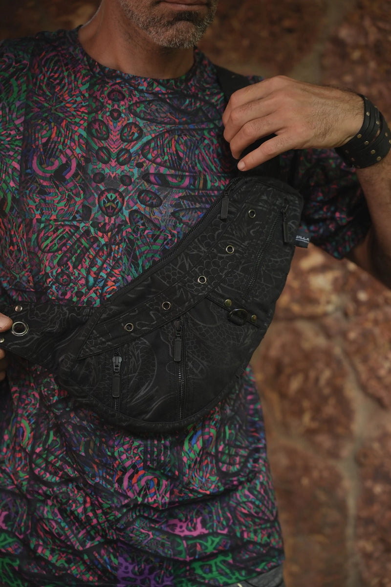 Close-up of the Vanta Dragon bag's strap buckle, metal eyelets and dark patterned fabric