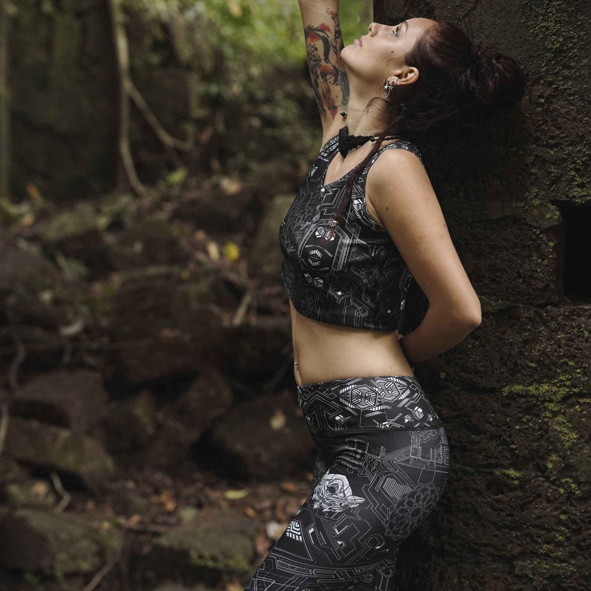 Woman wearing Source Code women's rave leggings with geometric print in a forest setting
