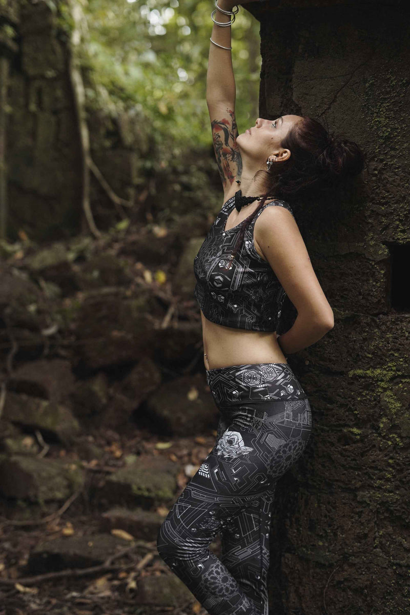 Woman wearing Source Code women's rave leggings with geometric print in a forest setting