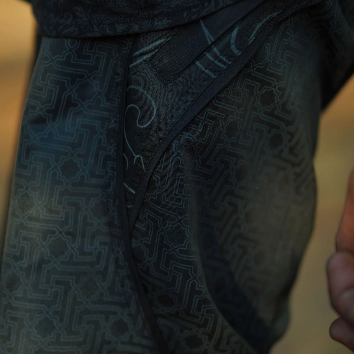 black festival swim shorts with geometric pattern pocket detail